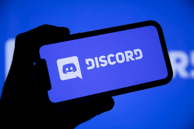 Hand holding smartphone with open Discord application